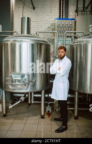 Portrait d'un technologue caucasien professionnel expert en uniforme blanc debout dans une usine pharmaceutique ou alimentaire - usine de production Banque D'Images