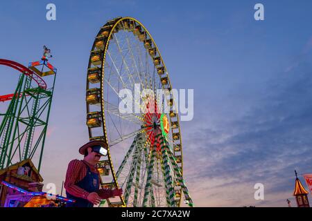 Vue à angle bas de la grande roue illuminée de Bellevue, célèbre roue géante du festival annuel de la foire de Rheinkirmes, contre un beau crépuscule Banque D'Images