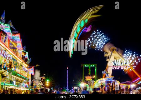 Paysage nocturne avec exposition longue et technique de vitesse d'obturation lente de couleur éclairant jaune pendule de promenade à Rheinkirmes. Banque D'Images