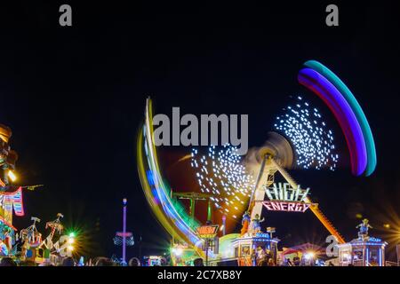Paysage nocturne avec exposition longue et technique de vitesse d'obturation lente de couleur éclairant jaune pendule de promenade à Rheinkirmes. Banque D'Images