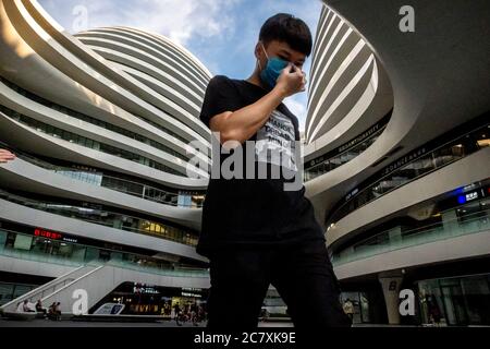 Pékin, Chine. 19 juillet 2020. Homme portant un masque de protection qui traverse le centre commercial Galaxy SOHO à Beijing, Chine le 19/07/2020 Beijing a abaissé son urgence épidémique de santé publique du deuxième au troisième niveau par Wiktor Dabkowski | usage dans le monde crédit: dpa/Alay Live News Banque D'Images