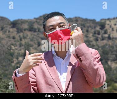 Hollywood, Californie, États-Unis. 17 juillet 2020. L'animateur de télévision Joey Zhou montre son masque avec un label américain de drapeau dans le cadre de son émission d'interview pandémique COVID-19 à Hollywood, en Californie. Joey Zhou est l'hôte du 'Zhou Zheng Show' et fondateur de Beverly Arts et de la Beverly News. Sheri Determan/Alamy.com Banque D'Images