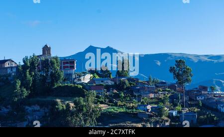 Photo hypnotique d'une petite ville dans la haute région andine de Cusco, Pérou sous un ciel bleu clair Banque D'Images