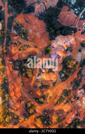 Gant, Hongrie - vue aérienne horizontale de drone de mine de bauxite abandonnée aux couleurs chaudes rouge et orange et arbre au coucher du soleil. Texture bauxite rouge Banque D'Images