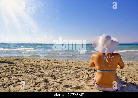 jeune femme en bikini un chapeau blanc sur la plage Banque D'Images