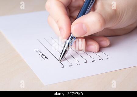 femme remplissant la liste des tâches avec un stylo bleu Banque D'Images