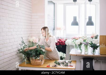 Belle jeune femme souriante plantes fleuriste organiser in flower shop Banque D'Images