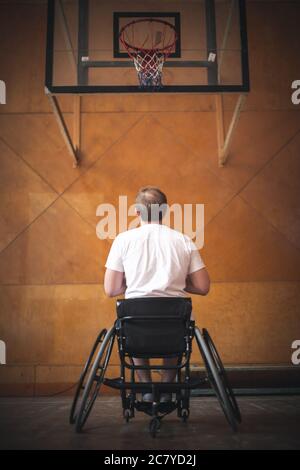 vue arrière d'un joueur de basket-ball à jeter librement posez en fauteuil roulant à l'intérieur Banque D'Images