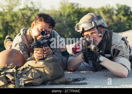 Paire de Rangers de l'armée à coups de mitrailleuse et déplacement le long de la paroi de béton en mission. Ils sont prêts à faire feu si l'ennemi s'affichent. Piscine loc Banque D'Images