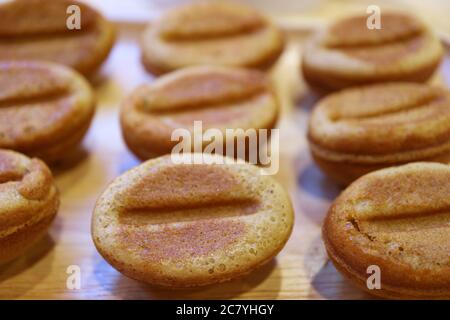 Gros plan de délicieux petits gâteaux faits maison en forme de grains de café sur un plateau en bois Banque D'Images