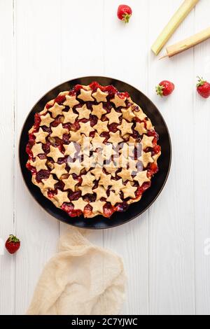 Tarte aux fraises et au rhubarbe décorée d'étoiles sur une table blanche, vue sur le dessus Banque D'Images