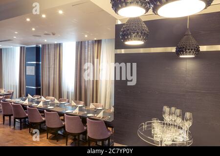 Hall à demi-éclairage de style loft dans un restaurant mexicain avec cuisine ouverte sur le fond. En face de la cuisine il y a des tables en bois avec mu Banque D'Images