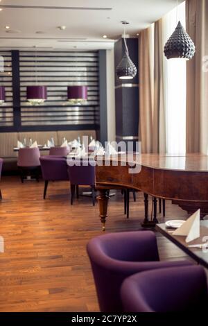 Hall à demi-éclairage de style loft dans un restaurant mexicain avec cuisine ouverte sur le fond. En face de la cuisine il y a des tables en bois avec mu Banque D'Images