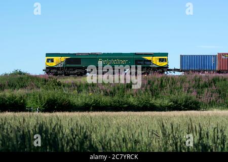 Classe 66 locomotive diesel n° 66504 tirant un train freightliner, vue latérale, Warwickshire, Royaume-Uni Banque D'Images