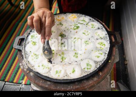 À la main et à la cuillère, cueillir Kanom Krok ou sorte de sucreries thaïlandaises, dessert thaï sur un plateau, faire des bonbons Banque D'Images