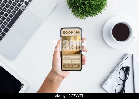 Vue ci-dessus femme utilisant un smartphone, recherche hôtel en ligne Banque D'Images
