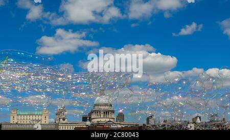 Des bulles de savon géantes flottent dans le ciel bleu profond devant la cathédrale St Paul à Londres, Angleterre, Royaume-Uni Banque D'Images