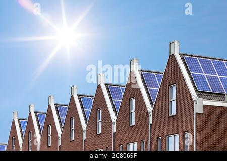 Maisons récemment construites avec panneaux solaires fixés sur le toit contre un ciel ensoleillé Banque D'Images