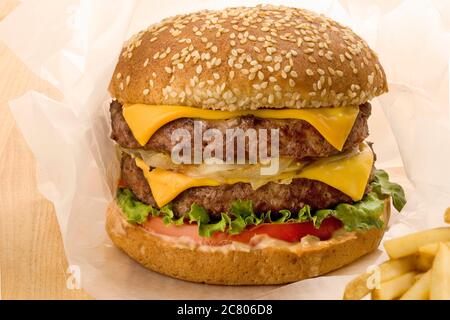 Double cheeseburger en papier avec frites Banque D'Images