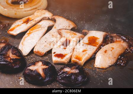 Cuisine japonaise teppanyaki avec barbecue aux champignons et sauce shoyu et éclairage intérieur. Banque D'Images