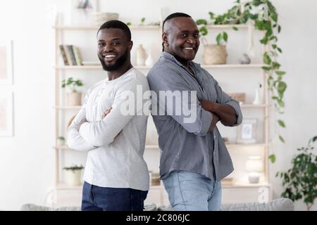 Deux générations. Heureux Noir Homme debout dos à dos avec le père senior Banque D'Images