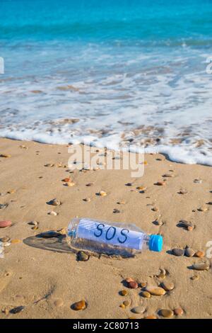 La contamination en plastique de la mer. Message SOS dans une bouteille en plastique au bord de la mer. Banque D'Images