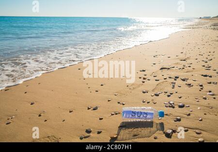 La contamination en plastique de la mer. Message SOS dans une bouteille en plastique au bord de la mer. Banque D'Images