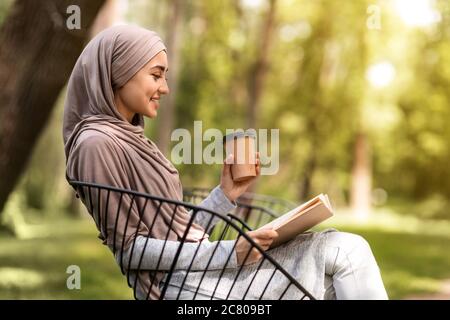 Photo de profil de la fille arabe livre de lecture à la ville parc Banque D'Images