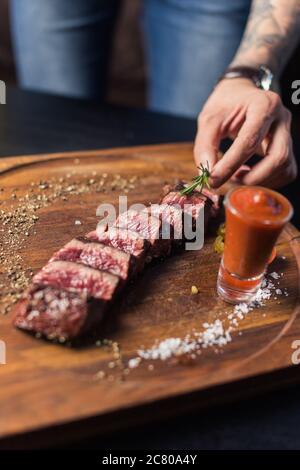 Steak de bœuf avec légumes grillés et assaisonnement sur le bloc de service Banque D'Images