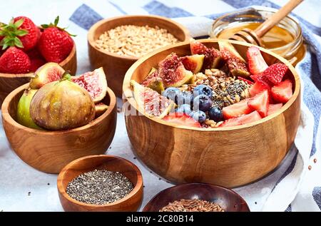 Ingrédients sains pour le petit déjeuner et le petit déjeuner, flocons d'avoine avec fruits et baies, figues, bleuets, fraises, graines de lin et de chia. Banque D'Images