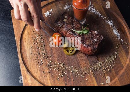 Steak de bœuf avec légumes grillés et assaisonnement sur le bloc de service Banque D'Images