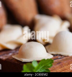 Raviolis faits maison sur une planche en bois. Banque D'Images