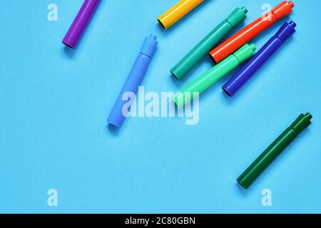 Stylos à pointe feutre colorés sur fond bleu avec emplacement pour le texte. Vue de dessus, espace de copie. Concept de retour à l'école. Banque D'Images