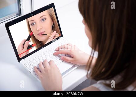 vue arrière de la jeune femme regardant la beauté blog vidéo sur ordinateur portable Banque D'Images