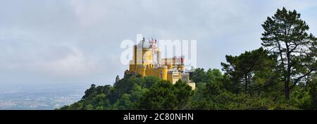 Vue sur le Palais national de Pena et le parc environnant de Sintra dans le magnifique lever de soleil brumisateur d'été, Portugal Banque D'Images