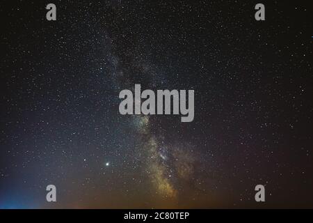 Ciel étoilé de nuit avec étoiles brillantes. Lueur brillante des planètes Saturne et Jupiter dans le ciel parmi les étoiles de la voie lactée Galaxy. Ciel dans les lumières de l'aube au coucher du soleil Banque D'Images