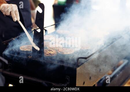 Le processus de cuisson des côtelettes de viande pour les hamburgers lors de la fête de mariage Banque D'Images