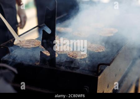 Le processus de cuisson des côtelettes de viande pour les hamburgers lors de la fête de mariage Banque D'Images