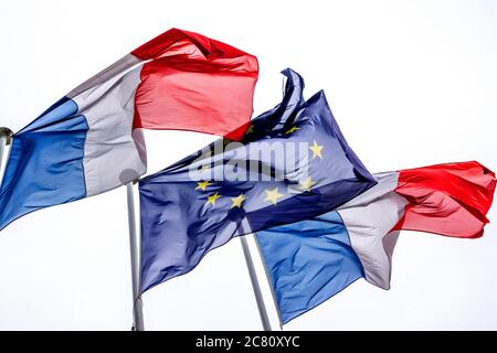 Drapeaux de la France et de l'Union européenne agitant au vent contre un ciel nuageux Banque D'Images