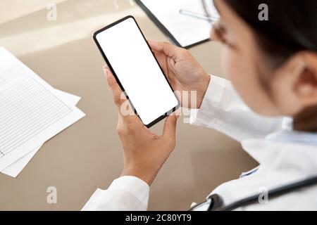 Femme indienne tenant avec le téléphone maquette écran blanc sur l'épaule vue. Banque D'Images