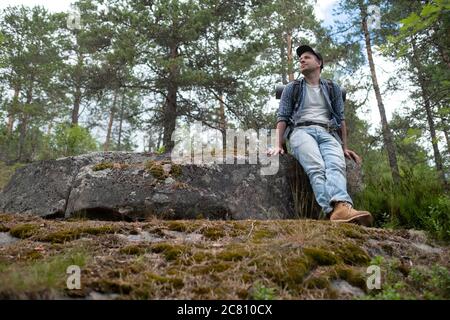 Jeune homme caucasien randonnée dans la forêt ayant un repos Banque D'Images