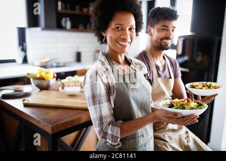 Beau jeune couple la cuisson des aliments sains ensemble à la maison. Avoir du plaisir dans la cuisine. Banque D'Images