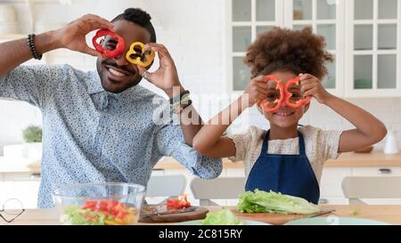 Portrait de sourire le père et la fille biracial ont plaisir à cuisiner Banque D'Images