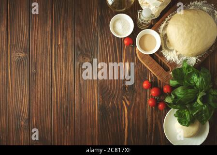 Cuisine rurale. Pâte et ingrédients pour cuire des pizzas sur une table en bois brun vintage. Vue de dessus. Arrière-plan rustique Banque D'Images