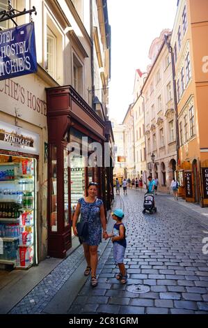 PRAGUE, RÉPUBLIQUE TCHÈQUE - 24 juillet 2019 : femme et enfant marchant dans une petite rue avec des boutiques dans le centre-ville Banque D'Images