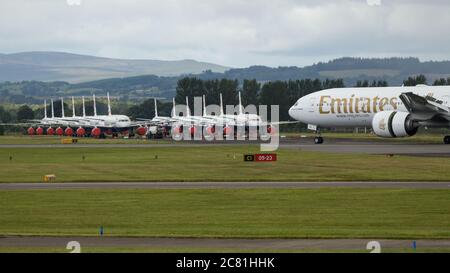 Glasgow, Écosse, Royaume-Uni. 20 juillet 2020. Photo : vol Emirates au départ de Dubaï vu atterrir à l'aéroport de Glasgow avec un grand groupe d'airbus British Airways (BA) mis au sol en arrière-plan. Crédit : Colin Fisher/Alay Live News Banque D'Images