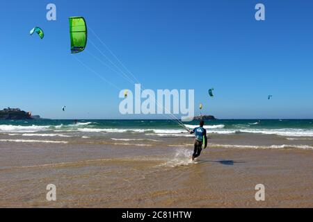 Kitesurfer ou kiteboarder marchant avec le cerf-volant dans le surf Kitesurf de la plage de Somo sur un vent ensoleillé Après-midi Santander Cantabria Banque D'Images