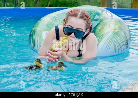 Jeune femme dans la cour au-dessus de la piscine avec caneton Banque D'Images