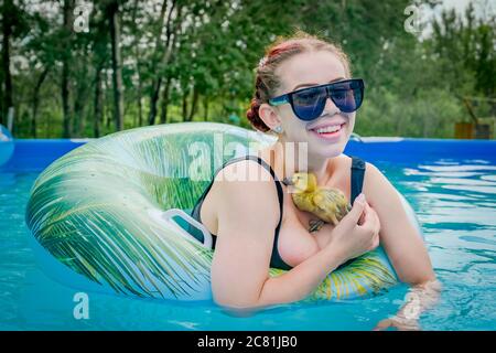 Jeune femme dans la cour au-dessus de la piscine avec caneton Banque D'Images