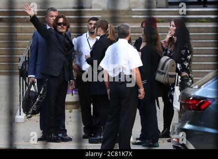 L'acteur Johnny Depp (à gauche) se démène en direction de photographies et de personnes dans la rue après avoir rencontré un groupe de fans dans la cour avant de quitter la haute Cour à Londres à la suite d'une audience dans son procès en diffamation contre les éditeurs du Sun et son rédacteur en chef, DaN Wootton. Banque D'Images